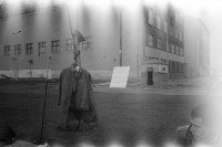 Image of sheet 19900720 photo 18: Am Checkpoint Charlie verkaufen Polen alte DDR Uniformen, die DDR Fahne und vieles mehr. Im Hintergrund die US Flagge an einem Lastwagen und ein Plakat der Deutsch Künstleragentur präsentiert Udo Lindenberg. Former Chepoint Wallborder to Eas-Germany GFR. An old Polish Citizen is sitting near old military uniforms from various Eastern Countries. The Pole is selling thes uniforms to travellers who visit whatever is left over from the 'Wall'.
Der Checkpoint Charlie war einer der bekanntesten Berliner Grenzübergänge durch die Berliner Mauer zwischen 1961 und 1990. Er verband in der Friedrichstraße zwischen Zimmerstraße und Kochstraße (beim gleichnamigen U-Bahnhof) den sowjetischen mit dem US-amerikanischen Sektor und damit den Ost-Berliner Bezirk Mitte mit dem West Berliner Bezirk Kreuzberg. Der Kontrollpunkt wurde im August 1961 in Folge des Mauerbaus eingerichtet, um die Grenzübertritte des westalliierten Militärpersonals und ausländischer Diplomaten erfassen zu können.
Checkpoint Charlie (or Checkpoint C) was the name given by the Western Allies to the best-known Berlin Wall crossing point between East Berlin and West Berlin during the Cold War.

The Soviet Union prompted the erection of the Berlin Wall in 1961 to stem the flow of Eastern Bloc emigration westward through what had become a loophole in the Soviet border system, preventing escape over the city sector border from East Berlin to West Berlin. Checkpoint Charlie became a symbol of the Cold War, representing the separation of east and west, and—for some East Germans—a gateway to freedom. Soviet and American tanks briefly faced off at the location during the Berlin Crisis of 1961.

Doppelbelichtung