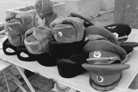 Image of sheet 19900730 photo 15: Am ehemaligen Checkpoint Charlie werden ausgediente Uniformen aus dem Osten feilgeboten. √ hut caps
Former Checkpoint Wallborder to East-Germany GFR. An old Polish Citizen is sitting near old military uniforms from various Eastern Countries. The Pole is selling these uniforms to travellers who visit whatever is left over from the 'Wall'. Berlin 1990
