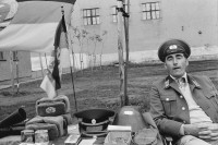 Image of sheet 19900730 photo 18: Am ehemaligen Checkpoint Charlie werden ausgediente Uniformen aus dem Osten feilgeboten. √ huts cap
Former Checkpoint Wallborder to East-Germany GFR. An old Polish Citizen is sitting near old military uniforms from various Eastern Countries. The Pole is selling these uniforms to travellers who visit whatever is left over from the 'Wall'. Berlin Deutschland 1990 Germany