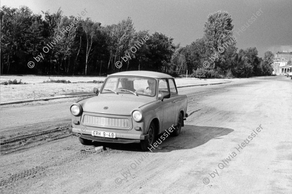 Image of sheet 19900730 photo 22: Ein Trabant wird vom Reichstag auf der Ebertstrasse, dem Mauerstreifen zum Potsdamerplatz gefahren. Berlin nach der Wende 1990 Ex DDR GDR Deutschland Germany transport car √ 
A Trabant is driven by the Reichstag on Ebert Street, where the Berlin Wall was, to the Potsdamer Platz. Berlin 

Trabant heißt die ab 1958 in der DDR in Serie gefertigte Pkw-Baureihe der Hersteller VEB Automobilwerk Zwickau und VEB Sachsenring Automobilwerke Zwickau. Zwischen November 1957 (Nullserie) und April 1991 wurden in Zwickau insgesamt 3.051.385 Fahrzeuge der Trabant-Baureihe produziert. Beim deutschen Kraftfahrt-Bundesamt waren zum 1. Januar 2011 noch genau 33.726 Fahrzeuge in Deutschland registrier