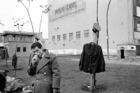 Image of sheet 19900730 photo 3: © 1990, OLIVIA HEUSSLER / www.clic.li
Am Checkpoint Charlie in Berlin verkaufen Polen alte DDR Uniformen und Flaggen etc. Im Hintergrund steht 'Neue Zeit'. Verkäufer ist uniformiert.  
Former Checkpoint Wallborder to East-Germany GDR. An Polish Citizen  near old military uniforms from various Eastern Countries. The Pole is selling these uniforms to travellers who visit whatever is left over from the 'Wall'.

Deutschland 1990 √

Checkpoint Charlie (or Checkpoint C) was the name given by the Western Allies to the best-known Berlin Wall crossing point between East Berlin and West Berlin during the Cold War.

The Soviet Union prompted the erection of the Berlin Wall in 1961 to stem the flow of Eastern Bloc emigration westward through what had become a loophole in the Soviet border system, preventing escape over the city sector border from East Berlin to West Berlin. Checkpoint Charlie became a symbol of the Cold War, representing the separation of east and west, and—for some East Germans—a gateway to freedom. Soviet and American tanks briefly faced off at the location during the Berlin Crisis of 1961.