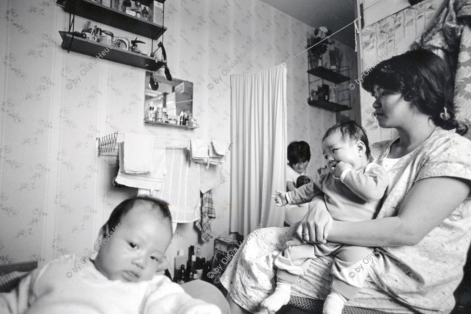 Image of sheet 19900770 photo 21: Im Wohnheim an der Rhinstrasse in Berlin, wohnen noch junge Mütter mit ihren Säuglingen. Die Fremdarbeiterinnen aus Vietnam, haben alle ihre Stelle verloren und die Väter ihrer Kinder sind verschwunden. 1.10.90 ehemalige DDR Deutschland 1990 √
Nguen Lan Anh (r) shares the room with two other young Vietnamese women ad their children babys. The three women all worked for the people owned mens clothing industry factory in Eastgermany, a firm called 'Fortschritt' (Progress). 
© 1990, OLIVIA HEUSSLER / www.clic.li