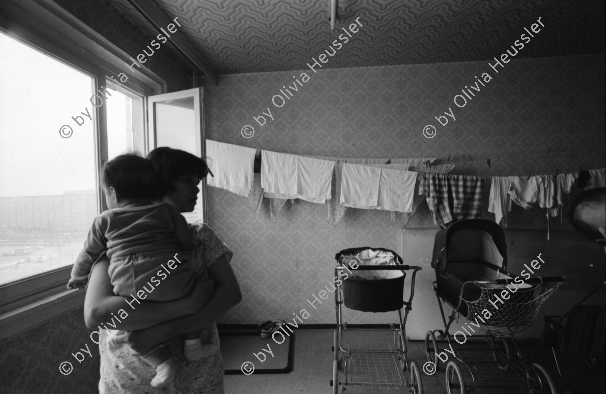 Image of sheet 19900770 photo 24: Strassenverkäufer in Pankow. Vietnamesische Fremdarbeiter Vertragsarbeiter Innen aus Vietnam als Textilnäherinnen in VEB Fortschritt Herrenbekleidung tätig.
 Im Wohnheim an der Rhinstrasse 91 D,Zimmer 5, Berlin 1136
 Friedrichsfelde Ost. S-Bahn. mit ihren Kleinkindern. Sie wohnen
 zu dritt mit ihren Kindern im selben Zimmer , abgetrennt mit
 Vorhängen. Die Väter der Kinder sind unbekannt. Die Frauen werden
 alle ausgeschafft.
Büro der Ausländerbeauftragten beim Ministerrat der DDR. Beratungsstelle für jüdische Emigranten.
 Im ehemaligen Reichsluftfahrtministerium fragen sovietische russische Juden und Jüdinnen um Asyl. Eine alte Frau schläft erschöpft auf ihrem Gepäck. Otto Grothewohlstr. 19 D
Reichspropaganda Ministerium. Das Reichsluftfahrtministerium (RLM) war ein Ministerium in der Zeit des Dritten Reichs. Für dieses Ministerium wurde 1935 ein monumentales Bürogebäude in Berlin errichtet, das seit 1992 Detlev-Rohwedder-Haus heißt und heute Sitz des Bundesministeriums der Finanzen ist.
Nguen Lun Huong Quang right, works at the advice centre for Vietnamese migrant workers in East-Berlin, former GDR. The advice centeris provisional and was set up very fast, because the demand for legal advice, how to avoid dismissalles , in connection with
 their work-situations as well as informationon possibilities to
 learn German, was very high.
 The general situation has worsened during the last months due to
 massdismisalles , because of measures seeking higher profits.
 The future of the Vietnamese industrial sewers for male clothing.
 working at the VEB Fortschritt is very unsure.As far as the living situation of these young mothers is concerned, they have to live on very little space and the cost of living is getting higher every day due to the political change.
Berlin 1990