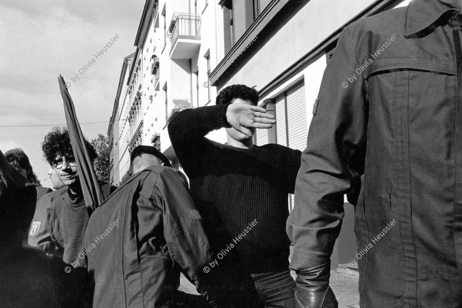 Image of sheet 19900790 photo 15: Junger Demonstrant verdeckt sich Augen und Gesicht während einer Polizeikontrolle am Protest gegen die Feierlichkeiten zur Wiedervereinigung von Ost- und Westdeutschland in Berlin, 02.Okt. 1990.  Deutschland vor der Wende.
Young left-winged activist is covering his face with his hand to keep his identity from whoever tries to take pictures from him. This reaction is the consequence of continuing police control in Berlin s streets. Especially as there is also a "Anti Reunification Movement" in Berlin. Police control protest manifester