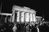 Image of sheet 19900790 photo 3: Der Reichstag in der Wiedervereinigungs Nacht. Durch TV Kamera. Jubelnde Menge am Brandenburger Tor. Nacht. 'Europa ohne Armee Deutschland zuerst 1914 1939 1990' Transparent. Helm und Schaf Maske. Portrait Larry Boyd in Berlin. Polizei kontrolliert und durchsucht  Demonstranten Innen gegen Wiedervereinigung. Grenadiere Transparent 'Gegen Rassismus und Grossdeutschland. 
Young left-winged activist is covering his face with his hand to keep his identity from whoever tries to take pictures from him. This reaction is the consequence of continuing police control in Berlin s streets. Especially as there is also a Anti Reunification Movement in Berlin Deutschland 1990