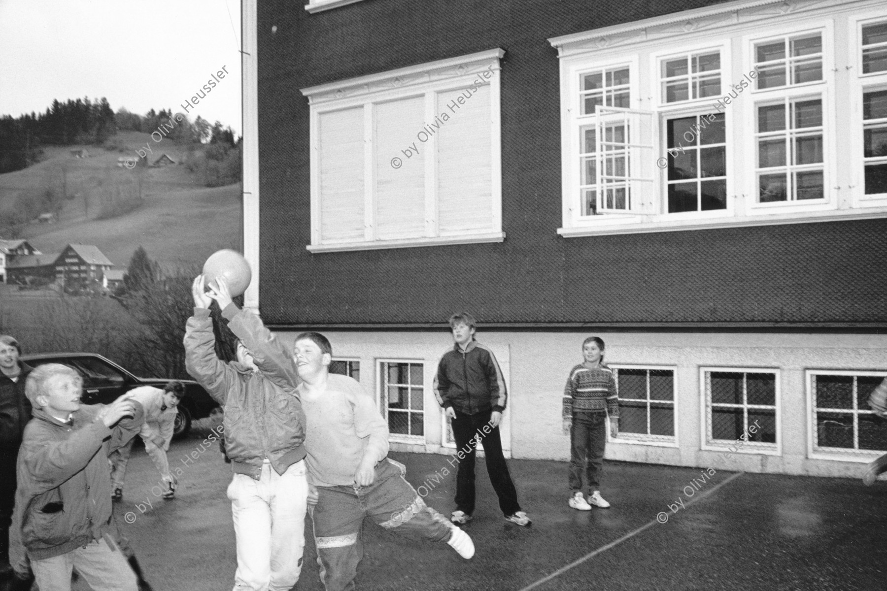 Image of sheet 19900930 photo 14: Schulklasse spielt vor Schulhaus auf Pausenhof. Primarschule Lehrer Thöny 5 und 6. Klasse. Urnäsch im Kanton Appenzell Ausserrhoden 1990 √ Volleyball