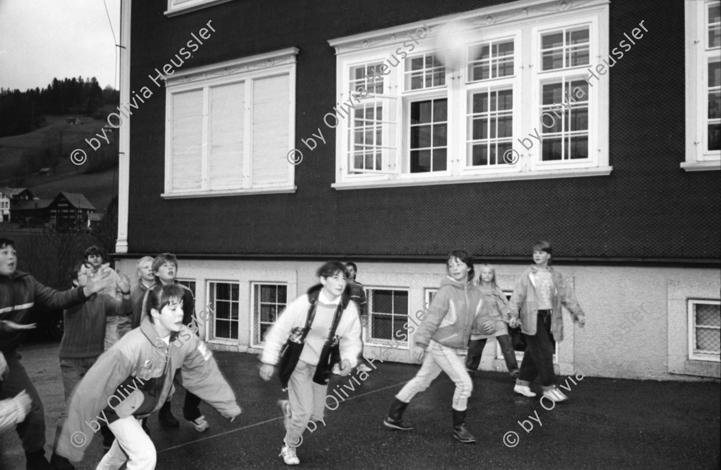 Image of sheet 19900930 photo 28: frtsg. 900920 Schulklasse spielt vor Schulhaus auf Pausenhof. Gruppenbild jedes Kind trägt die Flagge Fahne seines Herkunftsland. Eine Türkin etc. Primarlehrer Primarschule Lehrer Thöny vor seinen Photographien. 5 und 6. Klasse. Buben mit typischem Appenzeller Ohrschmuck. Urnäsch im Kanton Appenzell Ausserrhoden