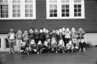 Image of sheet 19900930 photo 8: frtsg. 900920 Schulklasse spielt vor Schulhaus auf Pausenhof. Gruppenbild jedes Kind trägt die Flagge Fahne seines Herkunftsland. Eine Türkin etc. Primarlehrer Primarschule Lehrer Thöny vor seinen Photographien. 5 und 6. Klasse. Buben mit typischem Appenzeller Ohrschmuck. Urnäsch im Kanton Appenzell Ausserrhoden