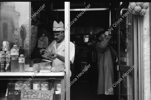 Image of sheet 19900960 photo 24: Strassenszenen Moschee. zwei alte Männer. Nikon Tafel. Bahnhof. Schnurrbart Schnautzmänner Schaufenster. Kebab Stand. Ein muslimisch fundamentalistisches Paar. Briefkasten und Kinder. Mann schleppt grosse Ladung auf Rücken. Bulgarinnen kaufen ein. Junge Gruppe Schulkinder. Spiegelungen. 1990 Türkei Istanbul