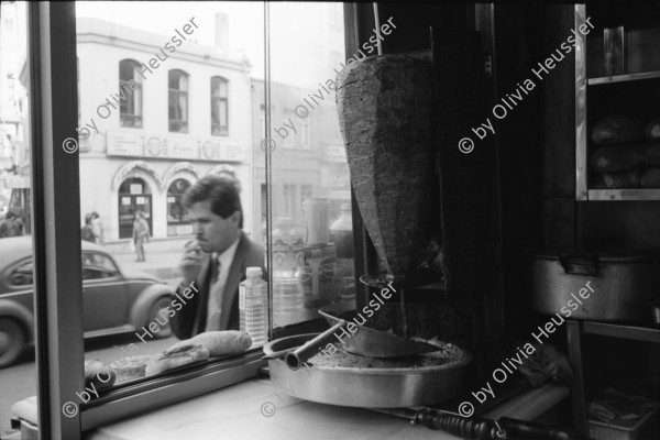 Image of sheet 19900960 photo 27: Strassenszenen Moschee. zwei alte Männer. Nikon Tafel. Bahnhof. Schnurrbart Schnautzmänner Schaufenster. Kebab Stand. Ein muslimisch fundamentalistisches Paar. Briefkasten und Kinder. Mann schleppt grosse Ladung auf Rücken. Bulgarinnen kaufen ein. Junge Gruppe Schulkinder. Spiegelungen. 1990 Türkei Istanbul