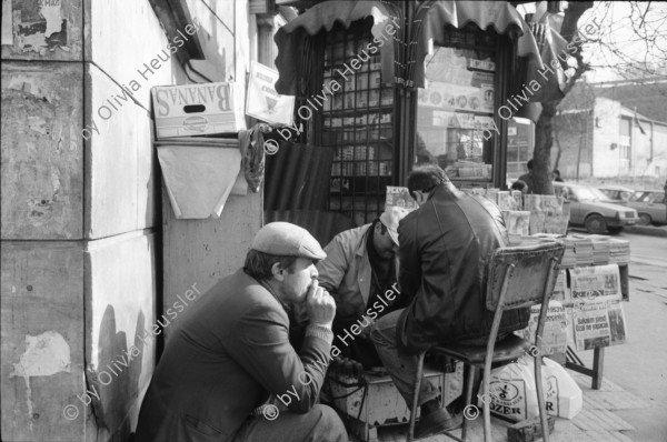 Image of sheet 19900960 photo 5: Strassenszenen Moschee. zwei alte Männer. Nikon Tafel. Bahnhof. Schnurrbart Schnautzmänner Schaufenster. Kebab Stand. Ein muslimisch fundamentalistisches Paar. Briefkasten und Kinder. Mann schleppt grosse Ladung auf Rücken. Bulgarinnen kaufen ein. Junge Gruppe Schulkinder. Spiegelungen. 1990 Türkei Istanbul