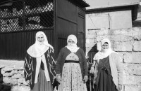 Image of sheet 19901030 photo 23: Dr. Karaman leitet als Arzt den Menschenrechtsverein in Nusaybin. Atatürk wacht auch über ihn und den Knaben.Bei der weissen Quelle auf dem Weg nach Seyhmehmet.Bauern Frauen waschen grosse Bleche am Fluss. Eine Frau trägt einen Kanister auf der Schulter. Sie trägt einen Schlüssel am Rock, was besagt, dass sie die Herrin im Haus ist und oder den Schlüssel zum Paradies besitzt.Kindergruppe. Mann pflügt mit Pferd den Acker. Am Postbüro PTT in Midyat kleben politische Propaganda Plakate gegen die PKK. Ein Schulhof, mit Atatürk s Siluette. Drei Frauen. Kohl wird ausgeladen. Die Frau schleppt und der Mann lächelt. Turkish Kurdish Kurdistan Kurds