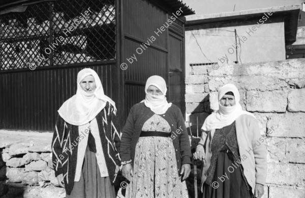 Image of sheet 19901030 photo 23: Dr. Karaman leitet als Arzt den Menschenrechtsverein in Nusaybin. Atatürk wacht auch über ihn und den Knaben.Bei der weissen Quelle auf dem Weg nach Seyhmehmet.Bauern Frauen waschen grosse Bleche am Fluss. Eine Frau trägt einen Kanister auf der Schulter. Sie trägt einen Schlüssel am Rock, was besagt, dass sie die Herrin im Haus ist und oder den Schlüssel zum Paradies besitzt.Kindergruppe. Mann pflügt mit Pferd den Acker. Am Postbüro PTT in Midyat kleben politische Propaganda Plakate gegen die PKK. Ein Schulhof, mit Atatürk s Siluette. Drei Frauen. Kohl wird ausgeladen. Die Frau schleppt und der Mann lächelt. Turkish Kurdish Kurdistan Kurds