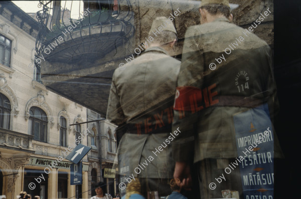 Image of sheet 19903002 photo 1: Illiescus vor Polizisten  in Brasov am 17. Mai 1990. Flowers in front of the policemen, from the fanatical part of the electoral rally of Iliescu.  

Protest; Blumen; Frauen; Polizei; Beamte; Maenner; Uniform; Brasov; Wahlen; 
Exhibition Bildbruchbild