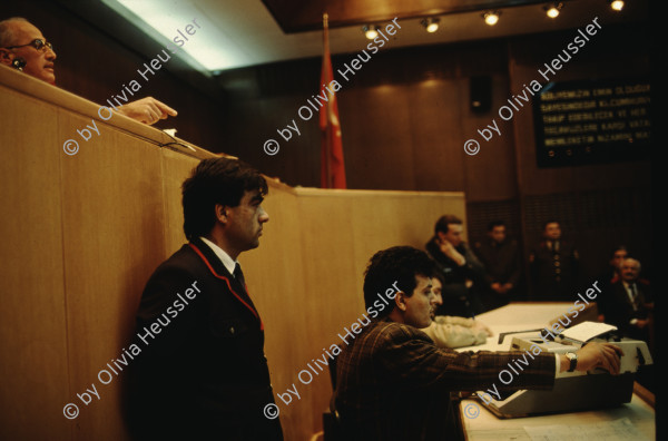 Image of sheet 19903006 photo 25: Im Staatsgericht Ankara. Der Prozess um den kurdischen Anwalt Vedat Aydin Nr. 5, der im Juli 91 von Todesschwadronen umgebracht wurde. Im Prozess wurden alle drei wegen Kurdisch sprechens verklagt, und später frei gesprochen. Mi: Ahmet Zeki Okçuoğlu, und re: Mustafa Oezer (HEP). In der Anklagebank. Umringt von türkischen Militärs. Die Verteidiger Innen, über 100, zogen sich unter Protest zurück und führten später ihre Plädoyer aus dem Zuschauerraum. Turkey Kurdish Kurds Die angeklagten kurdischen Anwälte v.l.n.r. Vedat Aydin, (Vedat Aydın, the Diyarbakır branch chairman of the now-defunct People’s Labor Party (HEP), was found dead on a road near Malatya on 7 July 1991, two days after armed men had taken him from his home in Diyarbakir.