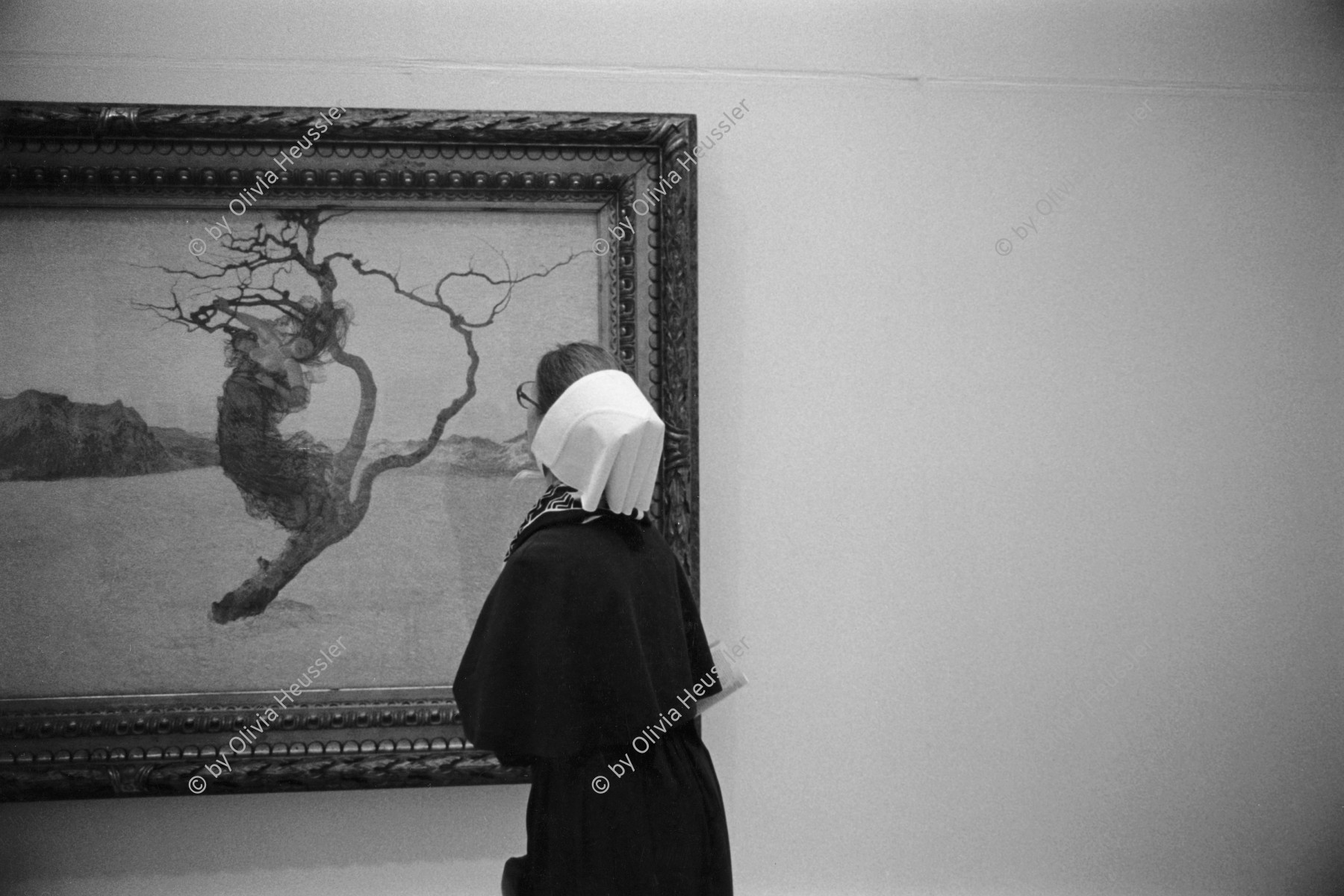 Image of sheet 19910010 photo 14: Eine Diakonission bestaunt im Zürcher Kunsthaus ein Bild vom Schweizer Maler Segantini. 12. 1990

A Diacone sister at Zurich Kunsthaus in front of a  painting of the Swiss painter and artist Giovanni Segantini. √
religion art 

A diaconia was originally an establishment built near a church building, for the care of the poor and distribution of the church's charity in medieval Rome or Naples (the successor to the Roman grain supply system, often standing on the very sites of its stationes annonae). Examples included the sites of San Vito, Santi Alessio e Bonifacio, and Sant'Agatha[1] in Rome, San Gennaro in Naples (headed by a deacon named John in the end of the ninth and the beginning of the tenth century.[2]

The word has now come to mean the titular church of a Cardinal Deacon.