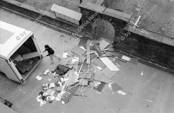 Image of sheet 19910100 photo 0: Erismannhof Jemand leerte seine Wohnung auf den Hof. Eine Wohnung wird geräumt. Portrait Elisabeth Schuler an Papyrus Pflanze . Wäne Heers und Urs Beuter. Baum ohne Blätter. Pinguin von Herr Müller, der Maler und Bildhauer. Seebahnstrasse. Verkehr Erismannhof Gebäude spiegelt sich auf Autodach. Eingang mit Brunnen. Aussersihl Kreis vier 4 Zürich 1991 Wohnen Siedlung