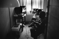 Image of sheet 19910182 photo 32: Afrikanische Flüchtlinge spielen in einem Zürcher Hotel Hirschen Video Games. Zürich Niederdorf √ refugees migration imigrants african black Switzerland Swiss 1991 watching tv media television in a hotel downtown