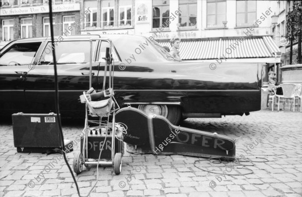 Image of sheet 19910220 photo 23: Strassenszenen in Antwerpen. Nachdenkliche Personen im Café. Frauen. Stühle aufgereiht. Hochzeitsfest in einer Kathedrale. Die Paare werden in grossen eleganten Fahrzeugen Autos abgeholt. Fensterputzerin. Strassenmusikant. Portrait Urs Tremp. Katzen liegen in einem Schaufenster. Drugstore Drogen 5.- Diener mit Mütze eines Chauffeurs einer Karosse. Zwei Mädchen sitzen in der Limousine. Uniform bilder. Belgien 1991