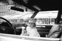 Image of sheet 19910220 photo 24: Strassenszenen in Antwerpen. Nachdenkliche Personen im Café. Frauen. Stühle aufgereiht. Hochzeitsfest in einer Kathedrale. Die Paare werden in grossen eleganten Fahrzeugen Autos abgeholt. Fensterputzerin. Strassenmusikant. Portrait Urs Tremp. Katzen liegen in einem Schaufenster. Drugstore Drogen 5.- Diener mit Mütze eines Chauffeurs einer Karosse. Zwei Mädchen sitzen in der Limousine. Uniform bilder. Belgien 1991