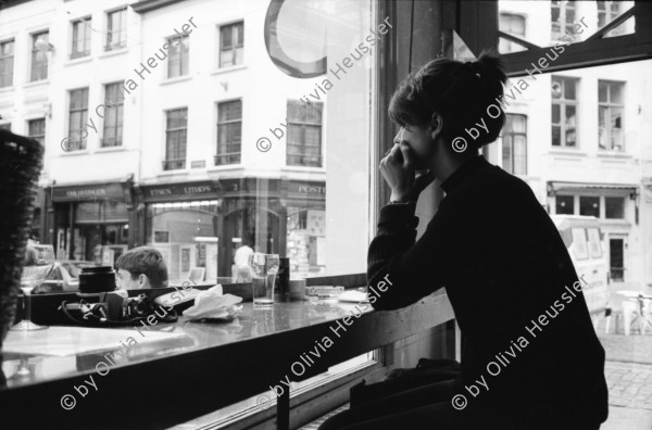 Image of sheet 19910220 photo 5: Strassenszenen in Antwerpen. Nachdenkliche Personen im Café. Frauen. Stühle aufgereiht. Hochzeitsfest in einer Kathedrale. Die Paare werden in grossen eleganten Fahrzeugen Autos abgeholt. Fensterputzerin. Strassenmusikant. Portrait Urs Tremp. Katzen liegen in einem Schaufenster. Drugstore Drogen 5.- Diener mit Mütze eines Chauffeurs einer Karosse. Zwei Mädchen sitzen in der Limousine. Uniform bilder. Belgien 1991