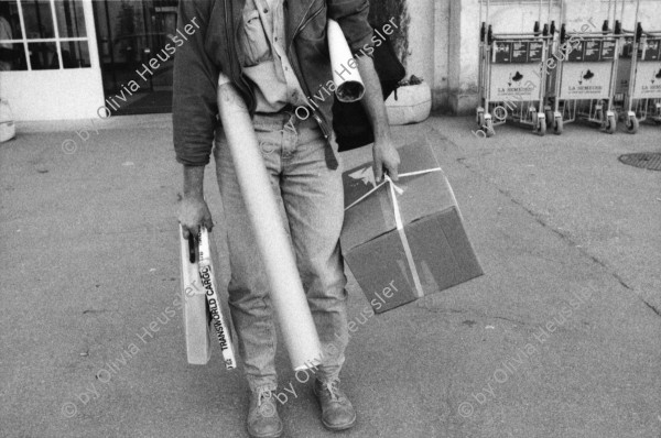 Image of sheet 19910231 photo 18: Der südamerikanische Fotograf John Liebenberg (1958 - 2020) hat Probleme mit dem Bahnpersonal, Schweiz 1991. Als Weltbürger kauft er eine Weltkugel. T-Shirt Born to be Swiss. Bahnhof. Gepäck In der Bahn hängt ein Photo von Johns Texte hängen auch da es sind Liebesgedichte an mich. Kanton vaud waadt Schweiz Suisse Switzerland 1991 Photographer Photography