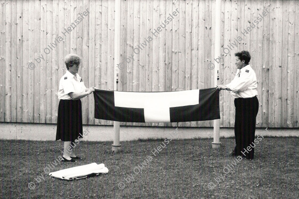 Image of sheet 19910540 photo 28: Die Schweizerfahne wird von  zwei Frauen in Uniform zusammengelegt. Bern 1. August 1991 (Nach 700 Jahrfeier) Nationaler Feiertag Fahne flagge 
Arranging the swiss flag by two women in uniforms. Berne, Switzerland, Swiss National Day, August 1st. 1991. Published by Libération, Paris.
(The 700 Jear Annyversary of Switzerland)