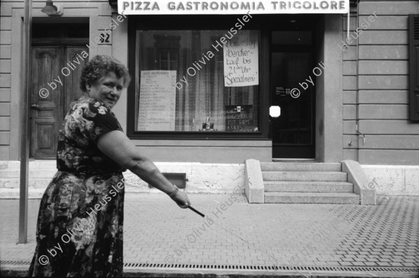 Image of sheet 19910550 photo 10: alter Brunnen Altstadt Bern. Leute sitzen in Biergarten. Italienische Pizzeria. Frau wird von Hund gezogen. Junger Punk sitzt auf Spielzeug. Mädchen vor Wandmalerei Graffiti Olivia. Kleiner portabler TV. Im Zug sitzt Franziska Oliver und Emanuel Tschumi. Olivia. Heussler 1991 Schweiz Bern