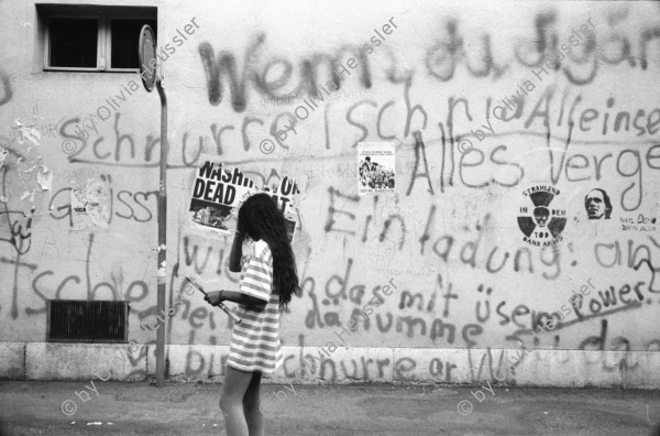 Image of sheet 19910550 photo 20: alter Brunnen Altstadt Bern. Leute sitzen in Biergarten. Italienische Pizzeria. Frau wird von Hund gezogen. Junger Punk sitzt auf Spielzeug. Mädchen vor Wandmalerei Graffiti Olivia. Kleiner portabler TV. Im Zug sitzt Franziska Oliver und Emanuel Tschumi. Olivia. Heussler 1991 Schweiz Bern