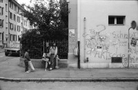 Image of sheet 19910550 photo 27: alter Brunnen Altstadt Bern. Leute sitzen in Biergarten. Italienische Pizzeria. Frau wird von Hund gezogen. Junger Punk sitzt auf Spielzeug. Mädchen vor Wandmalerei Graffiti Olivia. Kleiner portabler TV. Im Zug sitzt Franziska Oliver und Emanuel Tschumi. Olivia. Heussler 1991 Schweiz Bern
