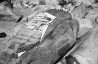 Image of sheet 19910570 photo 28: Flussbaden in der Melezza im Tessiner Centovalli ist immer mehr beliebt. Das von der Sonne gewärmte Felsgestein ist nach dem kalten Wasser eine Heizung. Die Frauen liegen bequem in den Nischen. Tegna the Best. Auf einem Frottier tuch ist eine  Frau abgebildet. Gummiboot und Männerschulter. Sandstrand  Männer sitzen in Badehosen auf den hohen Felsen. Ein ausgestopftes Krokodil (?) liegt hinter dem Heckfenster im Auto Fahrzeug. Zeitung lesend in der Hängematte. Tessin Ticino Pozzo 1991 Tourismus Baden Sonnen Bikini