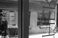 Image of sheet 19910680 photo 21: Portrait Pinkus Buchladen 20 Jahre Selbstverwaltung vor dem Laden an der Froschaugasse. Einkaufstüte Pinkus. Pierre ab 32 
Herbert an der Bändlistrasse 31 Auslieferung. Er sitzt auf dem Regal und liest ein Buch. Bücher in Armen.
Zürich 1991