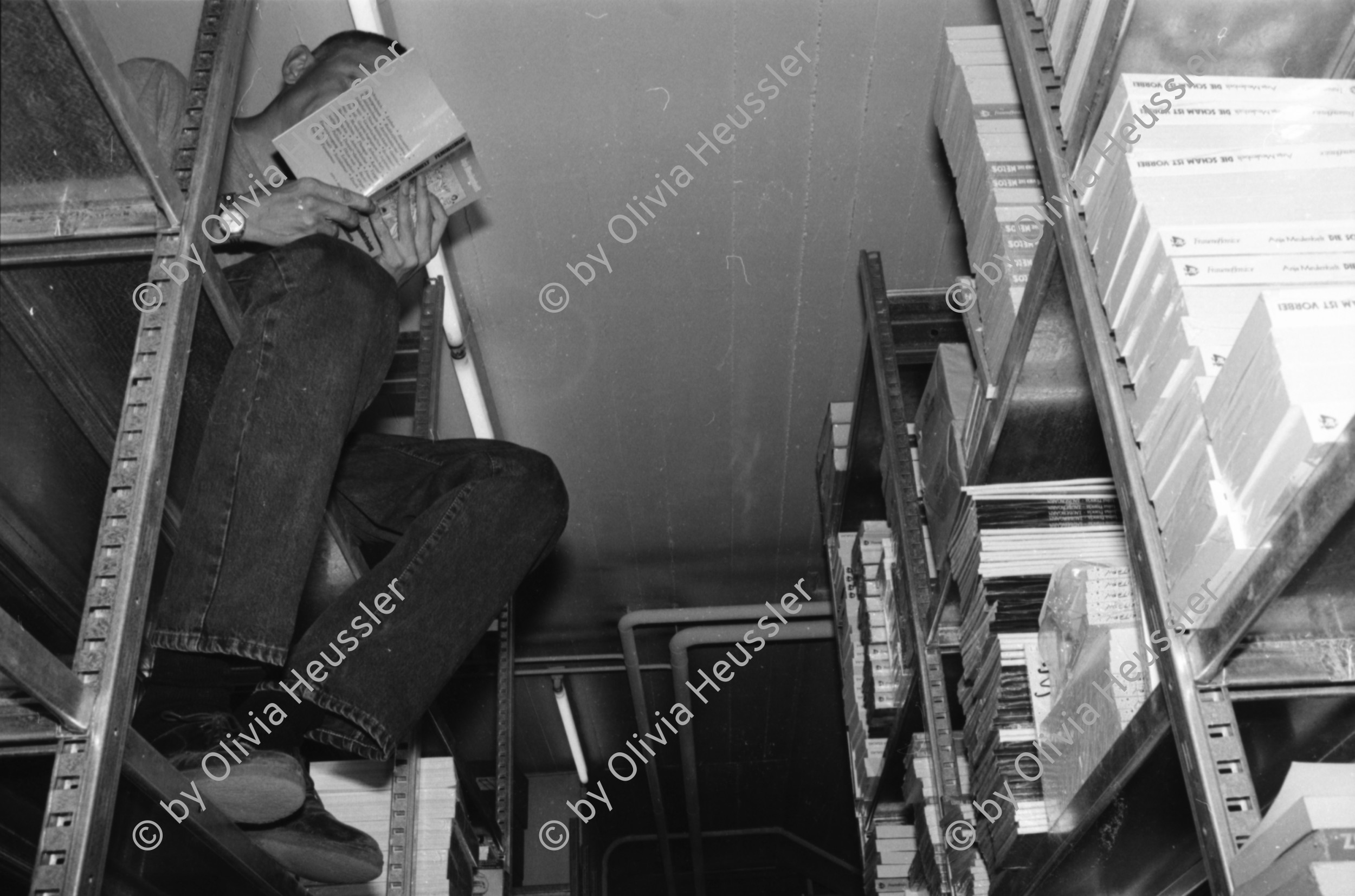 Image of sheet 19910680 photo 37: Portrait Pinkus Buchladen 20 Jahre Selbstverwaltung vor dem Laden an der Froschaugasse. Einkaufstüte Pinkus. Pierre ab 32 
Herbert an der Bändlistrasse 31 Auslieferung. Er sitzt auf dem Regal und liest ein Buch. Bücher in Armen.
Zürich 1991