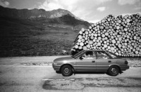 Image of sheet 19910700 photo 3: Während den Unwetttern von 1990 sind einige tausend Tonnen Holz gefallen. Hier wurde es neben der Passstrasse aufgeschichtet. Im Casino vom Kloster Disentis spielt Corin Curchellas mit Steve Agüelles und Stella Chiveshe und ihre Gruppe Earthquake. Graubünden Kanton Grisons 1991