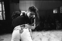 Image of sheet 19910830 photo 13: inm Kanzleischulhaus Turnhalle geht eine Schwinget voran. Schwingen auf Holzspähnen Ursina Jürg Bernhard Rof etc. Die beiden Gewinnerinnen werden auf den Schultern der Männer durch die Halle getragen. Ein Konzert fürs Fest auf dem Platz. Eine Wandmalerei von Barbara Ellmerer am Kreuzplatz. In der Baugrube. Tresa Deplazes in der F + F. Jürg Bernhard. Workshop F + F. Zürich Kreis 4 Aussersihl 1991