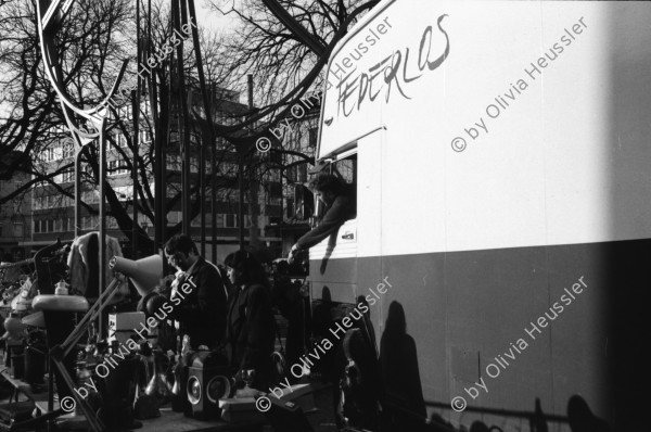 Image of sheet 19920010 photo 20: Flohmarkt im Kanzleischulhaus. Silvano Speranza fährt den Federlos Bus. Züglete vom Kanzlei. Plastik von Schang Hutter. Werbeplakat für Baer gescrached. Schulbänke liegen im Hof verbrannt. Rebecca Naldi. Schulhaus Portrait Kanzleischulhaus und brennende Schulbänke. Zürich 1992 pulte tables chairs burned fyer schule school 
housing occupation occupied house home protest swiss switzerland Schweiz Europe