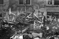 Image of sheet 19920010 photo 37: Flohmarkt im Kanzleischulhaus. Silvano Speranza fährt den Federlos Bus. Züglete vom Kanzlei. Plastik von Schang Hutter. Werbeplakat für Baer gescrached. Schulbänke liegen im Hof verbrannt. Rebecca Naldi. Schulhaus Portrait Kanzleischulhaus und brennende Schulbänke. Zürich 1992 pulte tables chairs burned fyer schule school 
housing occupation occupied house home protest swiss switzerland Schweiz Europe