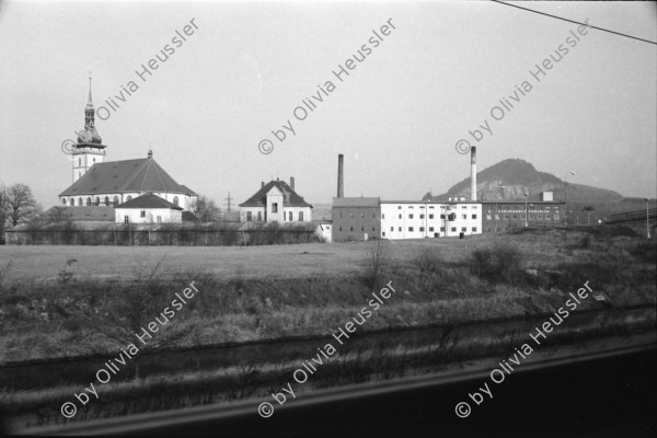 Image of sheet 19920080 photo 17: Der Fluss Elbe durch schmutziges Fenster. Es stehen Rucksäcke am Bahnhof von Usti mit Snackbar und sog. Pfadfinder oder eine Jugendgruppe. weibl. Bahnangestellte. Kohlebergwerk von Most. Mit Kirche. die auf Schienen früher weg transportiert wurde. Zug reihe. Wagons Tagabbaugebiet für Braunkohle Richtung Karlsbad, dem Erzgebirge entlang. Norden Tschechien Jirkov Bahnhof. Nordböhmen ehemaliges Sudetenland. Nach dem zweiten Weltkrieg wurden die mit Nazi Hitler sympatisierenden Sudeten, die deutsch sprachen, mit gerade 20kg Gepäck pro Person, ausgeschafft. Usti. Czech Republic. 1992