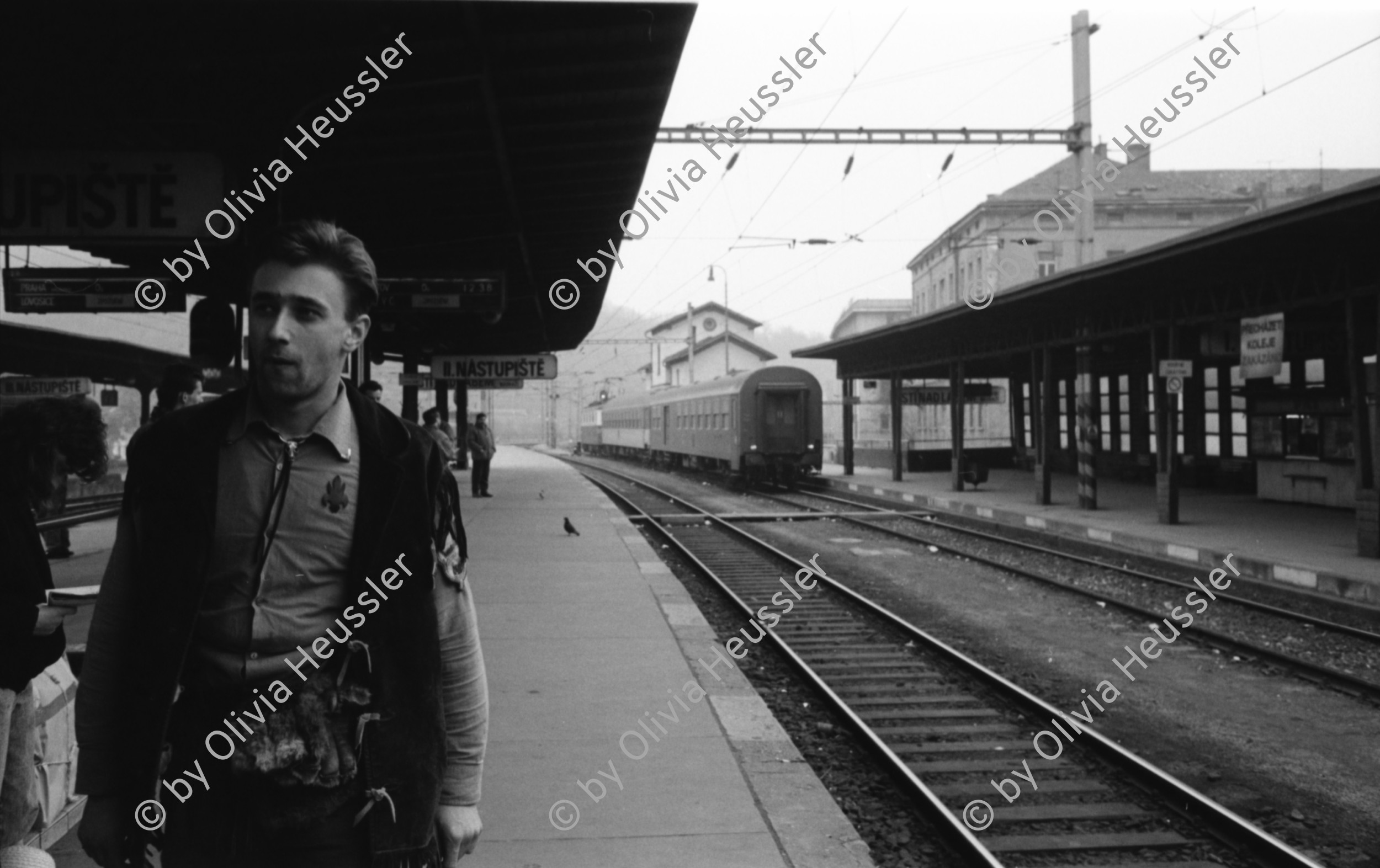 Image of sheet 19920080 photo 9: Der Fluss Elbe durch schmutziges Fenster. Es stehen Rucksäcke am Bahnhof von Usti mit Snackbar und sog. Pfadfinder oder eine Jugendgruppe. weibl. Bahnangestellte. Kohlebergwerk von Most. Mit Kirche. die auf Schienen früher weg transportiert wurde. Zug reihe. Wagons Tagabbaugebiet für Braunkohle Richtung Karlsbad, dem Erzgebirge entlang. Norden Tschechien Jirkov Bahnhof. Nordböhmen ehemaliges Sudetenland. Nach dem zweiten Weltkrieg wurden die mit Nazi Hitler sympatisierenden Sudeten, die deutsch sprachen, mit gerade 20kg Gepäck pro Person, ausgeschafft. Usti. Czech Republic. 1992