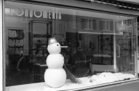 Image of sheet 19920130 photo 13: Schaufensterpuppe mit Brille auf Kniestrumpf in Simons's Brillenladen an der Oberen Zäune .Winterdekoration im Schaufenster der Kondome Condomeria (Kondomladen).Schneemann mit Kondomnase. und Knöpfen. Living Doll's bei Modeschau für Bally's Frühlingskollektion im Hotel Dolder. 1992 Zürich Schweiz