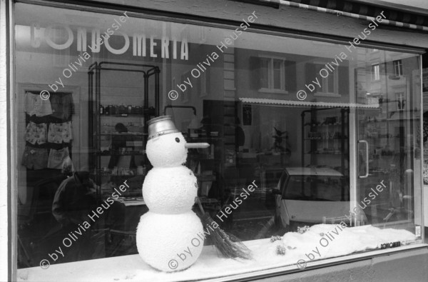 Image of sheet 19920130 photo 13: Schaufensterpuppe mit Brille auf Kniestrumpf in Simons's Brillenladen an der Oberen Zäune .Winterdekoration im Schaufenster der Kondome Condomeria (Kondomladen).Schneemann mit Kondomnase. und Knöpfen. Living Doll's bei Modeschau für Bally's Frühlingskollektion im Hotel Dolder. 1992 Zürich Schweiz