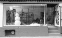 Image of sheet 19920130 photo 15: Schaufensterpuppe mit Brille auf Kniestrumpf in Simons's Brillenladen an der Oberen Zäune .Winterdekoration im Schaufenster der Kondome Condomeria (Kondomladen).Schneemann mit Kondomnase. und Knöpfen. Living Doll's bei Modeschau für Bally's Frühlingskollektion im Hotel Dolder. 1992 Zürich Schweiz