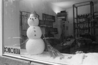 Image of sheet 19920130 photo 19: Schaufensterpuppe mit Brille auf Kniestrumpf in Simons's Brillenladen an der Oberen Zäune .Winterdekoration im Schaufenster der Kondome Condomeria (Kondomladen).Schneemann mit Kondomnase. und Knöpfen. Living Doll's bei Modeschau für Bally's Frühlingskollektion im Hotel Dolder. 1992 Zürich Schweiz