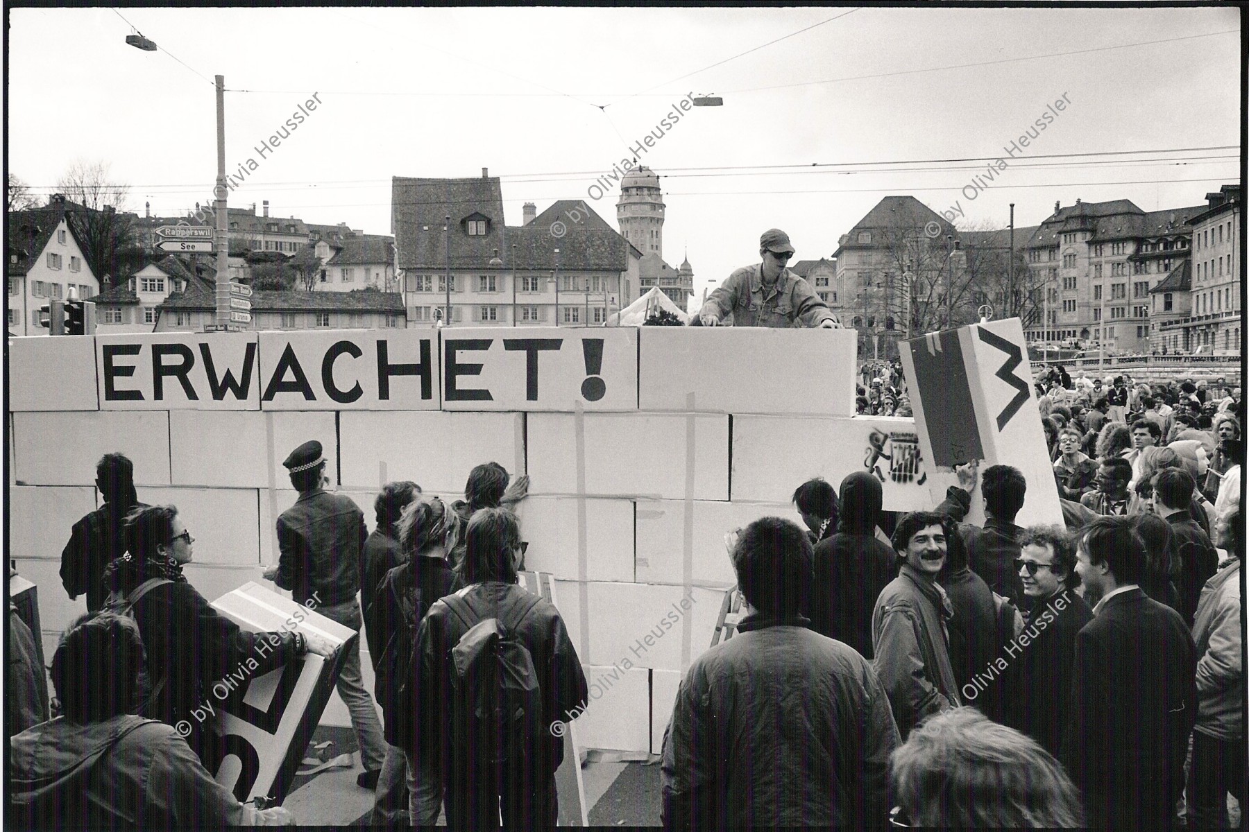 Image of sheet 19920200 photo 0: Die Aktionsmauer am Mühlequai 'Mauerblümchen erwachet' wird von engagierten Menschen aufgebaut. Protest gegen die Politik der Stadt Mühlequai Zürich, 03. 1992 Schweiz 
 	'Wake up ' is written on the wall in the center of Zurich. The manifestation turns into a springtime-party. Switzerland 03-21-92

zurück von Libération, Paris 2015