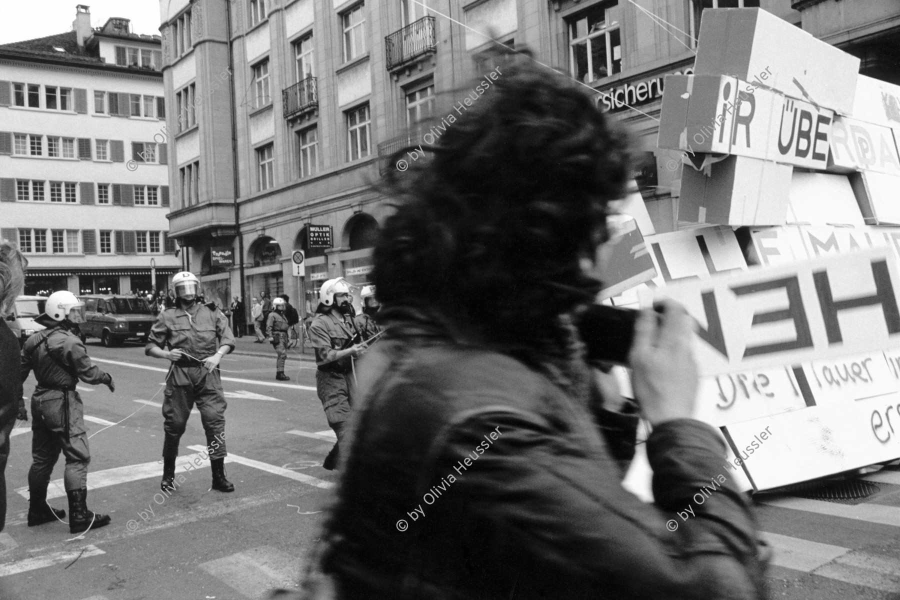 Image of sheet 19920200 photo 22: Die Aktionsmauer am Marktgasse  'Mauerblümchen erwachet' stürzt von Grenadieren geholfen zusammen. Zürich, 03. 1992 Protest Zürich Kreis 1 eins Limmatquai Schweiz Switzerland Swiss art protest