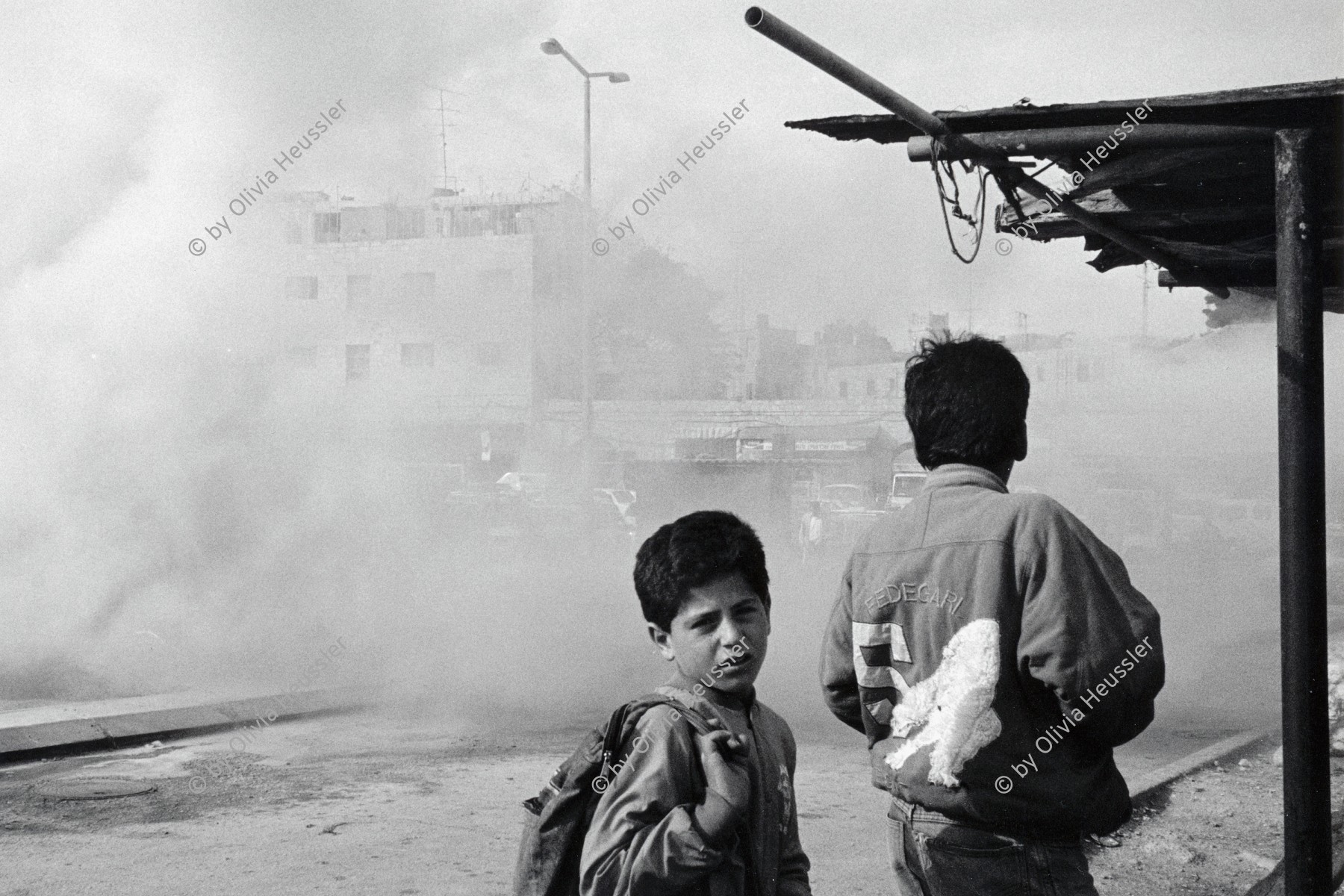 Image of sheet 19920280 photo 13: Oft werden  die neuen für Siedler günstig erwerbbaren Fahrzeuge  von jungen Palästinensern angezündet. Ost Jerusalem, Palästina 04.92 √
Palestinian children in East Jerusalem watching an Israeli car burning. boy school
Aus: Out of Jerusalem / Jenseits von Jerusalem page 18 / 19

copyright by Olivia Heussler
1992  Palestine israeli occupied territory