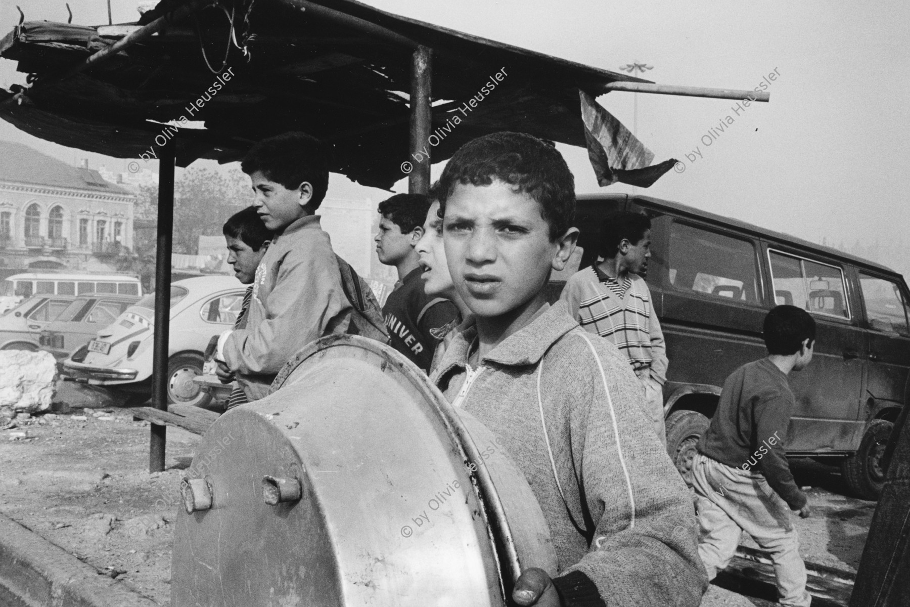 Image of sheet 19920280 photo 14: Oft werden  die neuen finanziell leicht erwerbbaren Autos der Siedler von jungen Palästinensern angezündet. Eine Gruppe von jungen Knaben beobachtet das Geschehen. Ost-Jerusalem, Palästina 04.92 √
Palestinian children in East-Jerusalem.