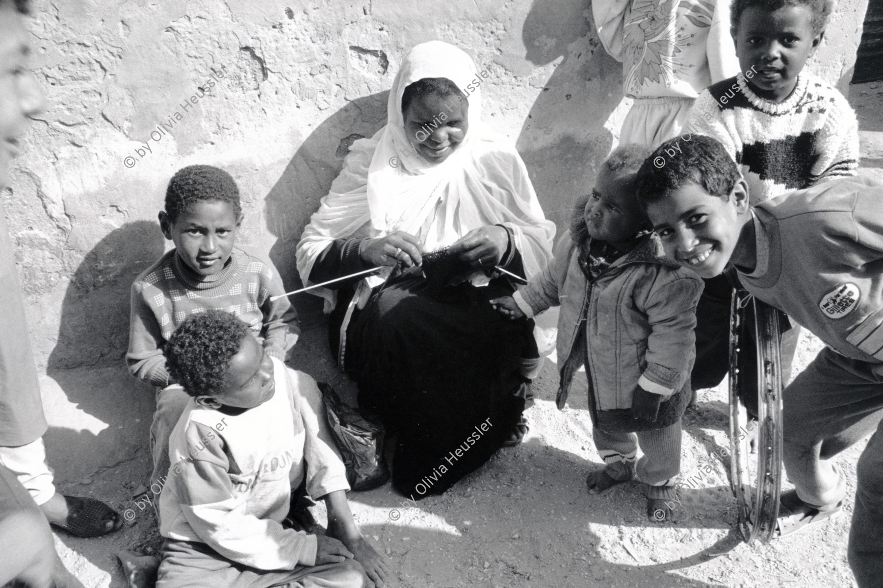 Image of sheet 19920300 photo 15: In einem Flüchtlingslager bei Khan Younis, Gazastreifen, Palästina 04.92
In a Refugee Camp near Deir Balah. Palestine Gaza strip israeli occupied territory 1992 √ Palestine woman mother kids children knits kniting palestinian kopftuch headscarf black arabic arabs arab refugees

© 1992, OLIVIA HEUSSLER / www.clic.li