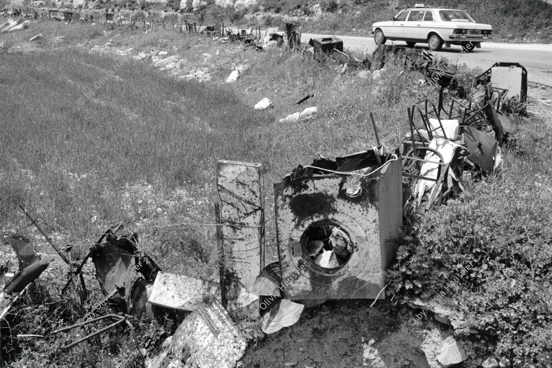 Image of sheet 19920330 photo 10: © 1992, Olivia Heussler / www.clic.li
Eine ausgediente Waschmaschine wird u.a. als Grenzmarkierung auf dem Feld eingesetzt. Bir Zeit , Westbank, Palästina. 04.92
Out of: Out of Jerusalem jenseits von Jerusalem page: 77 
Mercedes benz car washing machine
Used materials are marking the view. Palestine occupied territories 1992 √
Birzeit (Arabic: بيرزيت‎) (also written Bir Zeit) is a Palestinian town near Ramallah in the central West Bank. Its population in the 2007 census was 4529. Birzeit is a traditional Christian town. Its history dates back to the Byzantine era and earlier