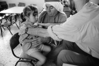 Image of sheet 19920400 photo 36: Dieses herzkranke Mädchen wird von einem israelischen Arzt Ralf Guggenheim, der Vereinigung israelisch Palästinensicher Aerzte und Aerztinnen für Menschenrechte (AIPPHR), untersucht. Tulkarm
copyright by Olivia Heussler

Israel Palestine 1992 √ medical asistant doctor hard girl clinic health help ngo human rights old man kuffiah sitting in front of